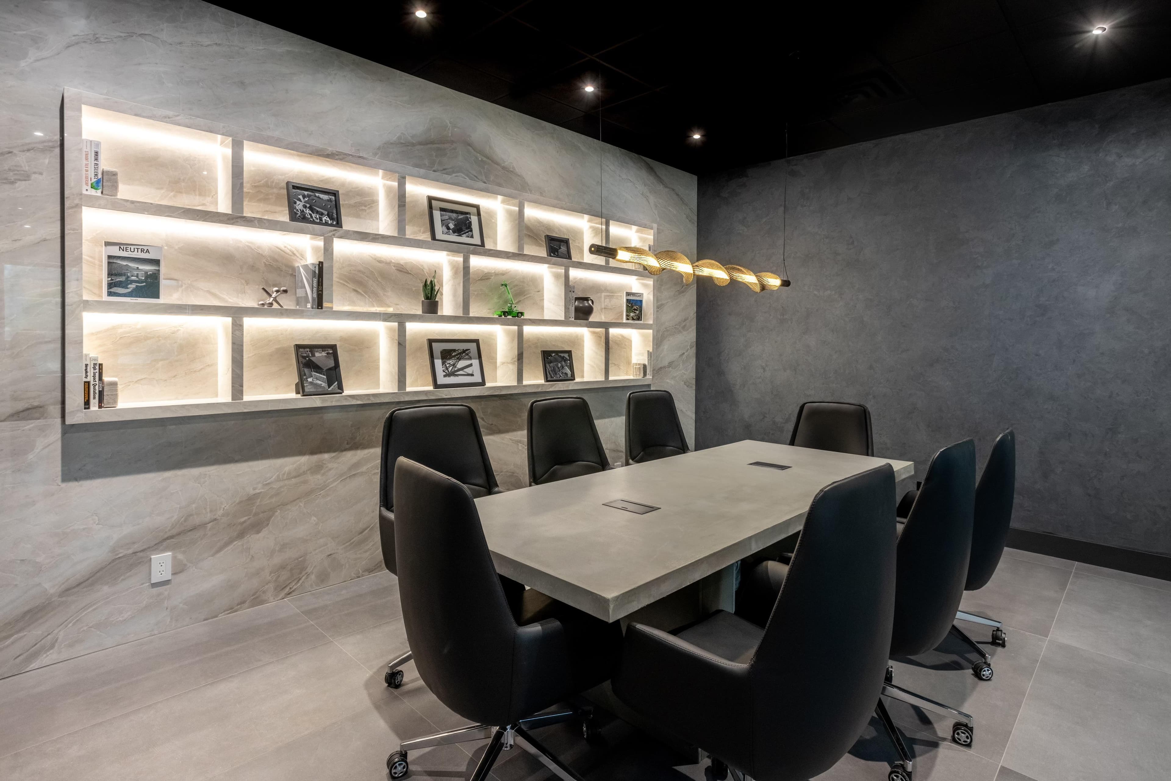 Office and shelf made with porcelain slabs and a big meeting table in the middle